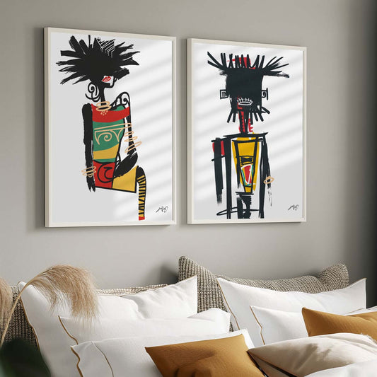 Two large pieces of abstract art featuring colorful figures with dark features and geometric shapes hanging on the wall above a sofa with white and beige cushions in a cozy living room. Artwotk by Kali Nuevo.