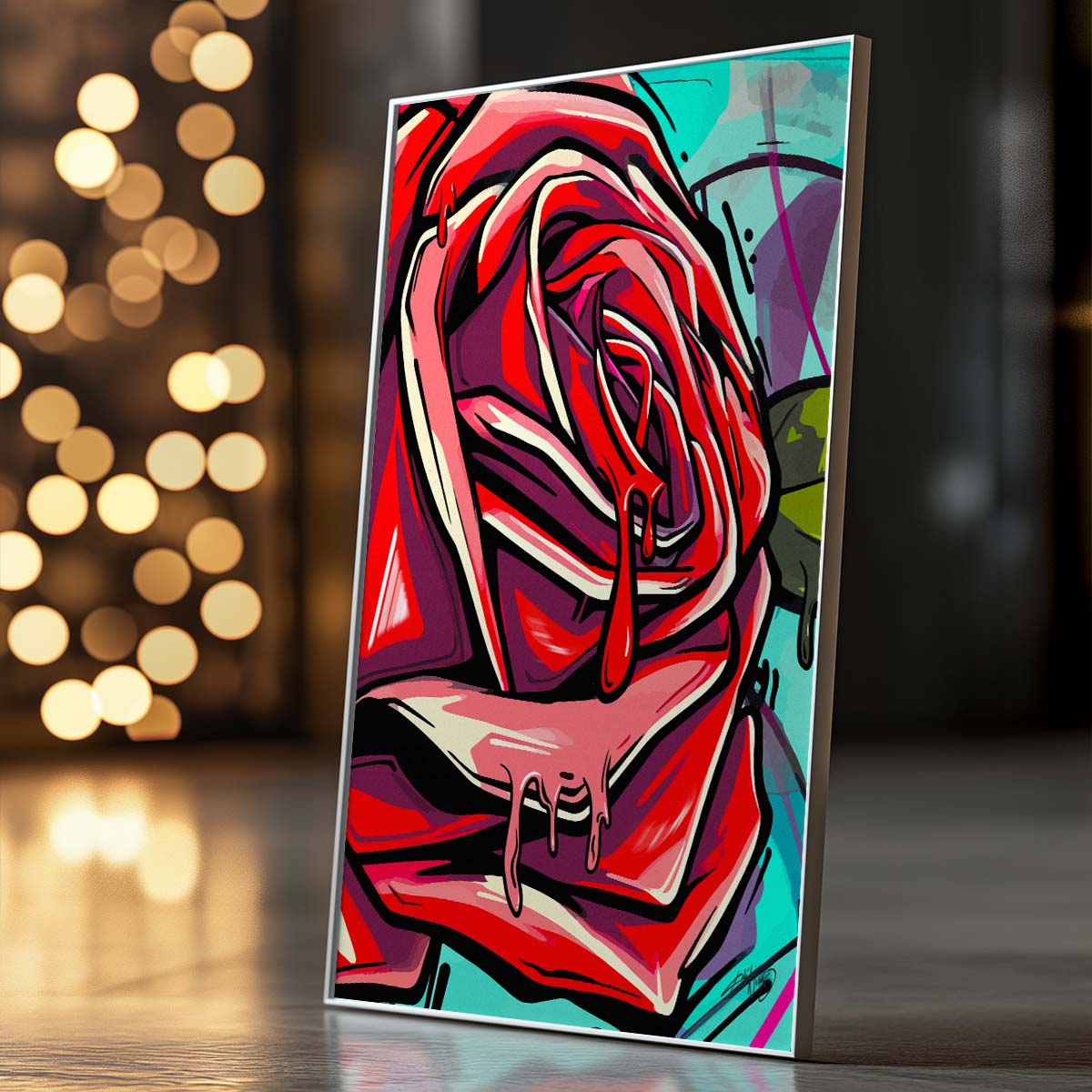 Three framed pieces of abstract artwork in red, green, pink, and blue colors with a rose motif hanging on the wall above a white bed with dark throw blanket and wooden nightstand with potted plant in a modern bedroom. Artwork by Kali Nuevo.