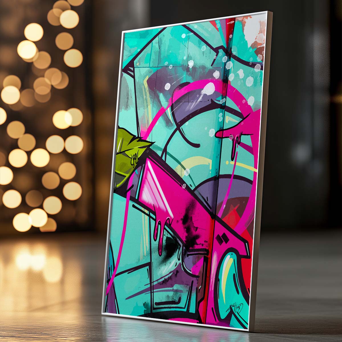 Three framed pieces of abstract artwork in red, green, pink, and blue colors with a rose motif hanging on the wall above a white bed with dark throw blanket and wooden nightstand with potted plant in a modern bedroom. Artwork by Kali Nuevo.