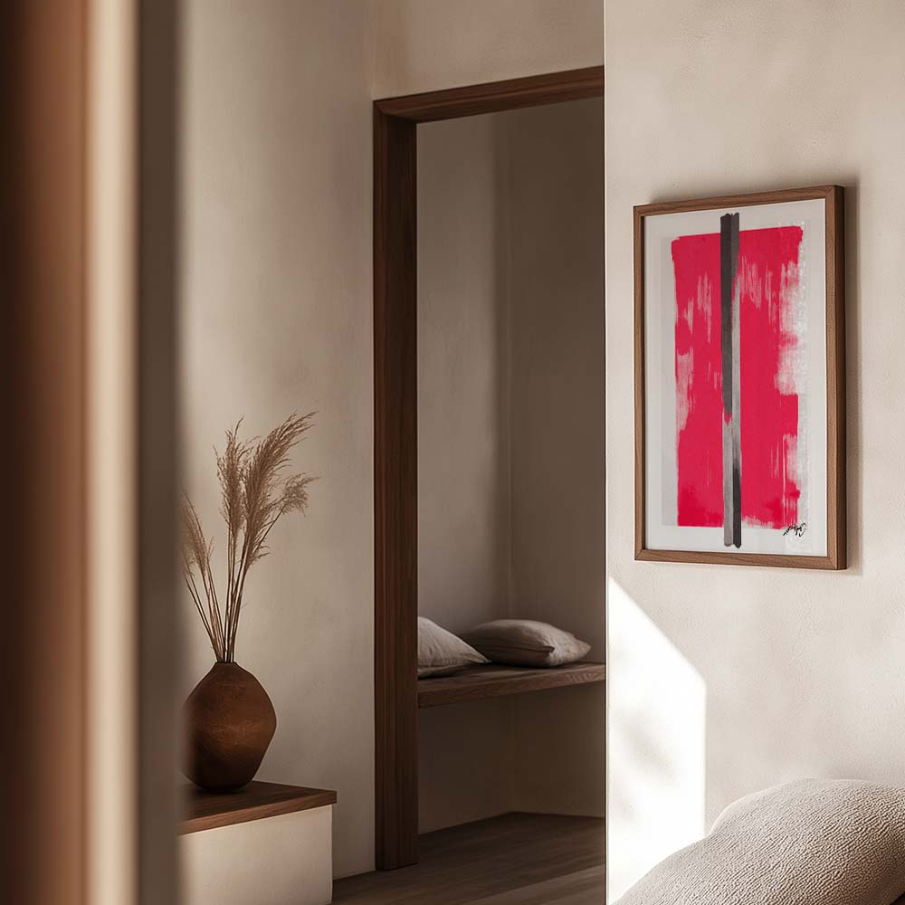 Rød kunstplakat med lodrette sorte penselstrøg, indrammet i egetræ og vist i et roligt og stilrent interiør. Design af Kali Nuevo.