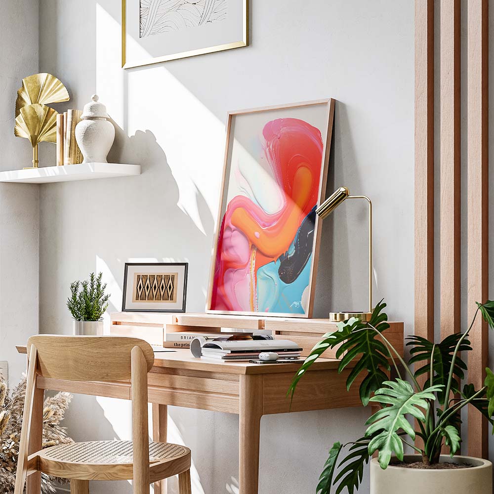 An orange, red and blue abstract painting on a white wall above a wooden sideboard with a lamp, a plant, and a candle.